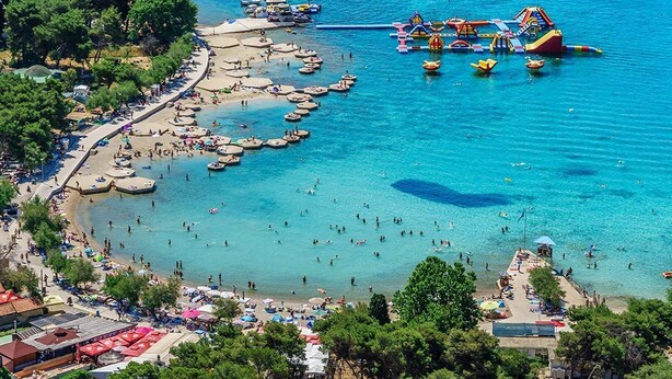 A coastal area with a beach, boats, and water activities. - Apartments Jak (Vodice)