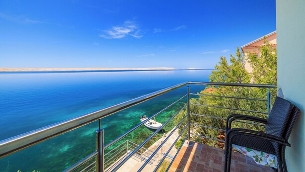 A balcony with a clear view of the sea and a boat. - Apartments Domagoj (Karlobag)
