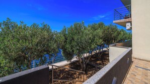 A balcony with a view of the sea, surrounded by olive trees. - Apartments Domagoj (Karlobag)