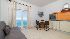 A modern kitchen with a built-in oven and a flat-screen TV. - Apartments Domagoj (Karlobag)
