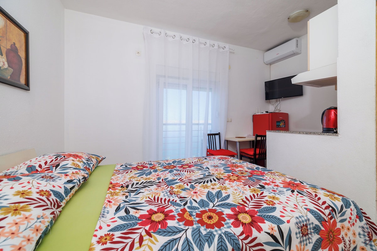 Ein Hotelzimmer mit Bett, Stuhl, Schreibtisch und Fernseher.