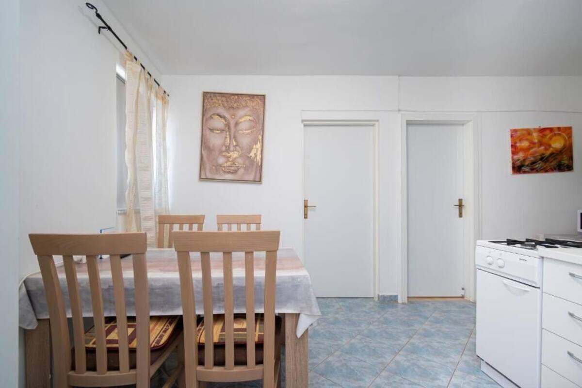 Un comedor con una mesa, sillas, una estufa y dos puertas.