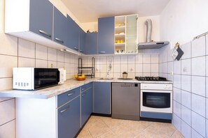 Apartment (A2) | Private kitchen | Fridge, stovetop, electric kettle, cookware/dishes/utensils - Apartments Soni (Postira)