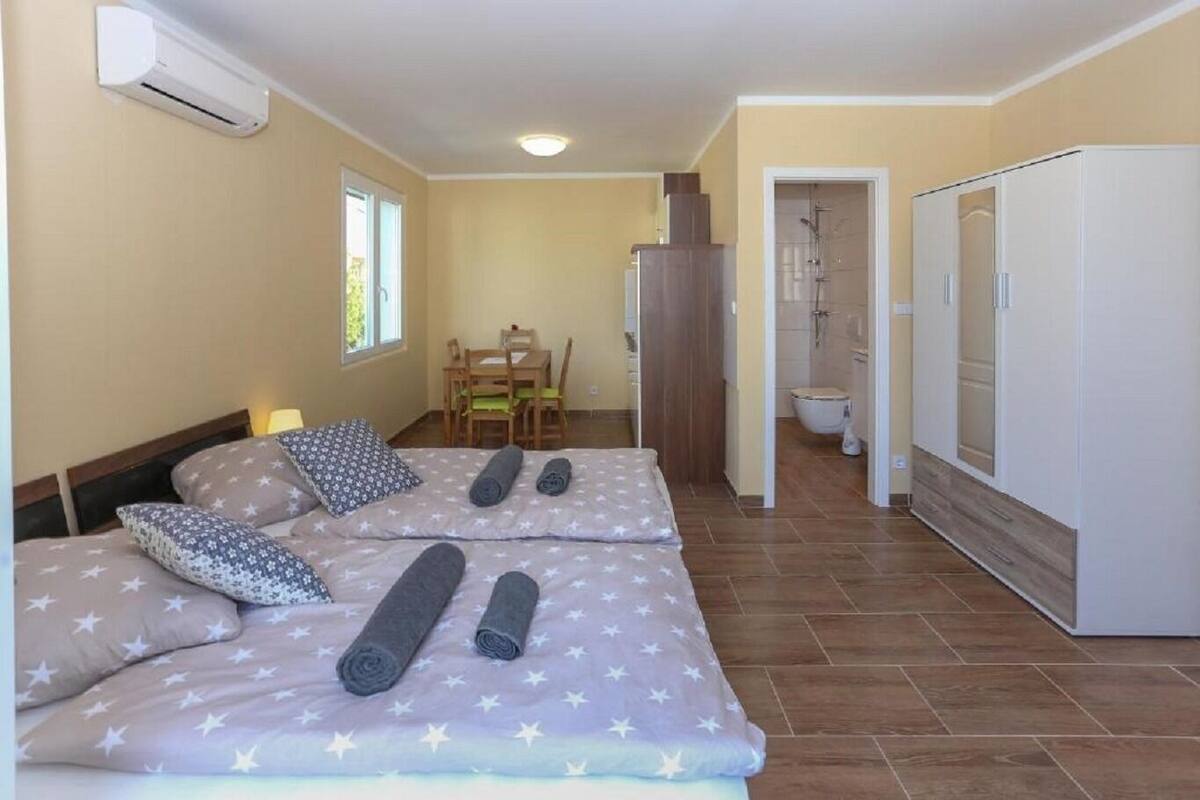 Een slaapkamer met twee bedden, een badkamer en een eethoek.