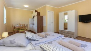 A bedroom with a bed, pillows, a TV, a wardrobe, a desk, and a chair. - Apartments Slavko With Terrace (Kastela)