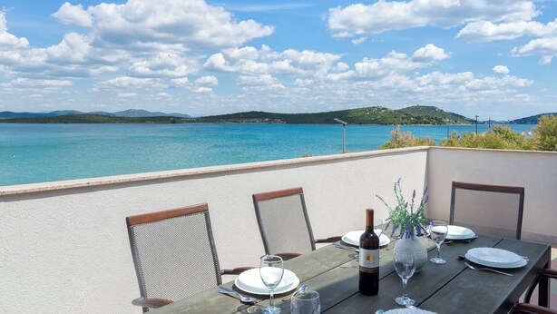 A table set for dining with a view of the sea and hills. - Apartment Denko by the sea (Tisno)