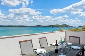 A table set for dining with a view of the sea and hills. - Apartment Denko by the sea (Tisno)