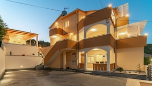 A multi-story building with a central courtyard, a staircase leading to the upper levels, and a reception area with a counter. - Apartments Lux 2 (Marina)