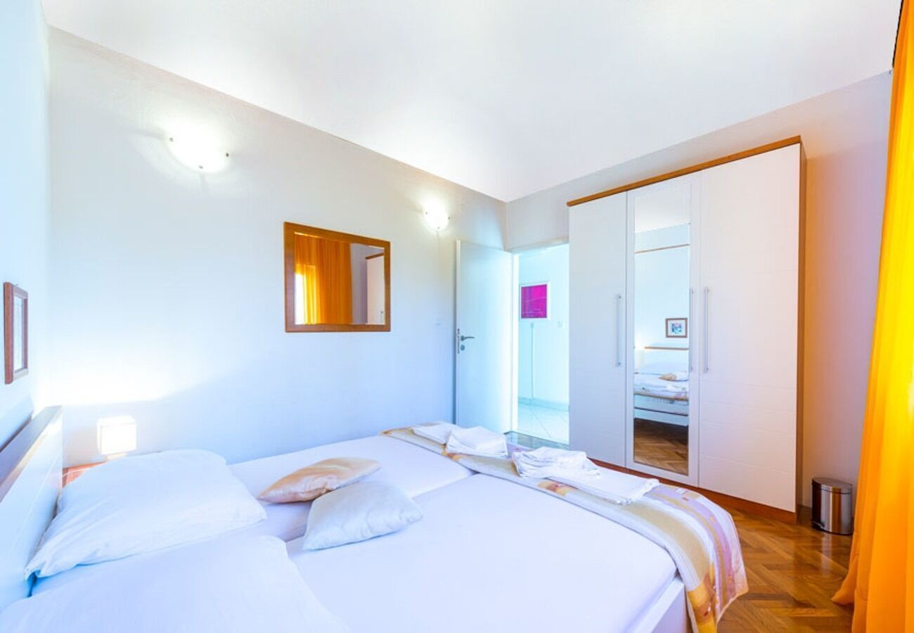 Habitación de hotel moderna con una cama grande, un armario y un baño visible a través de una puerta abierta.