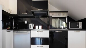 Eine moderne Küche mit Geschirrspüler, Backofen, Mikrowelle und Kaffeemaschine.