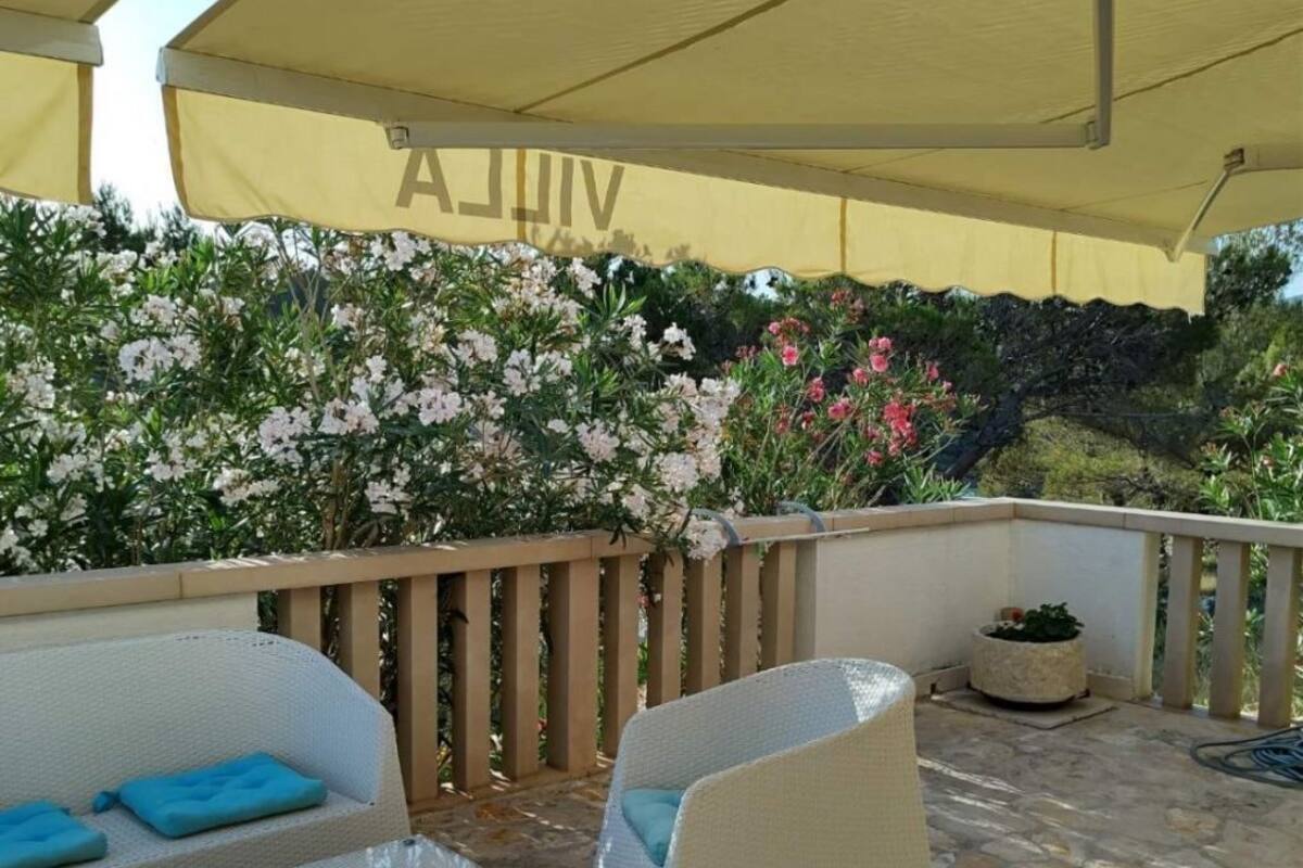 An outdoor patio with wicker furniture, a stone floor, and a yellow canopy.