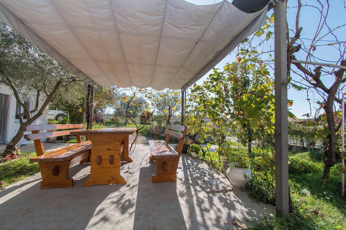 An outdoor seating area with wooden benches and a canopy.
