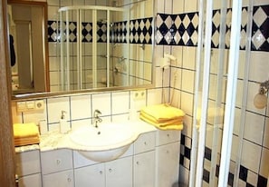 A bathroom with a sink, mirror, and tiled walls. - Apartments Martin (Rovinj)
