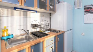 A kitchen with a sink, dish rack, and cabinets. - Apartments Sime (Novalja)