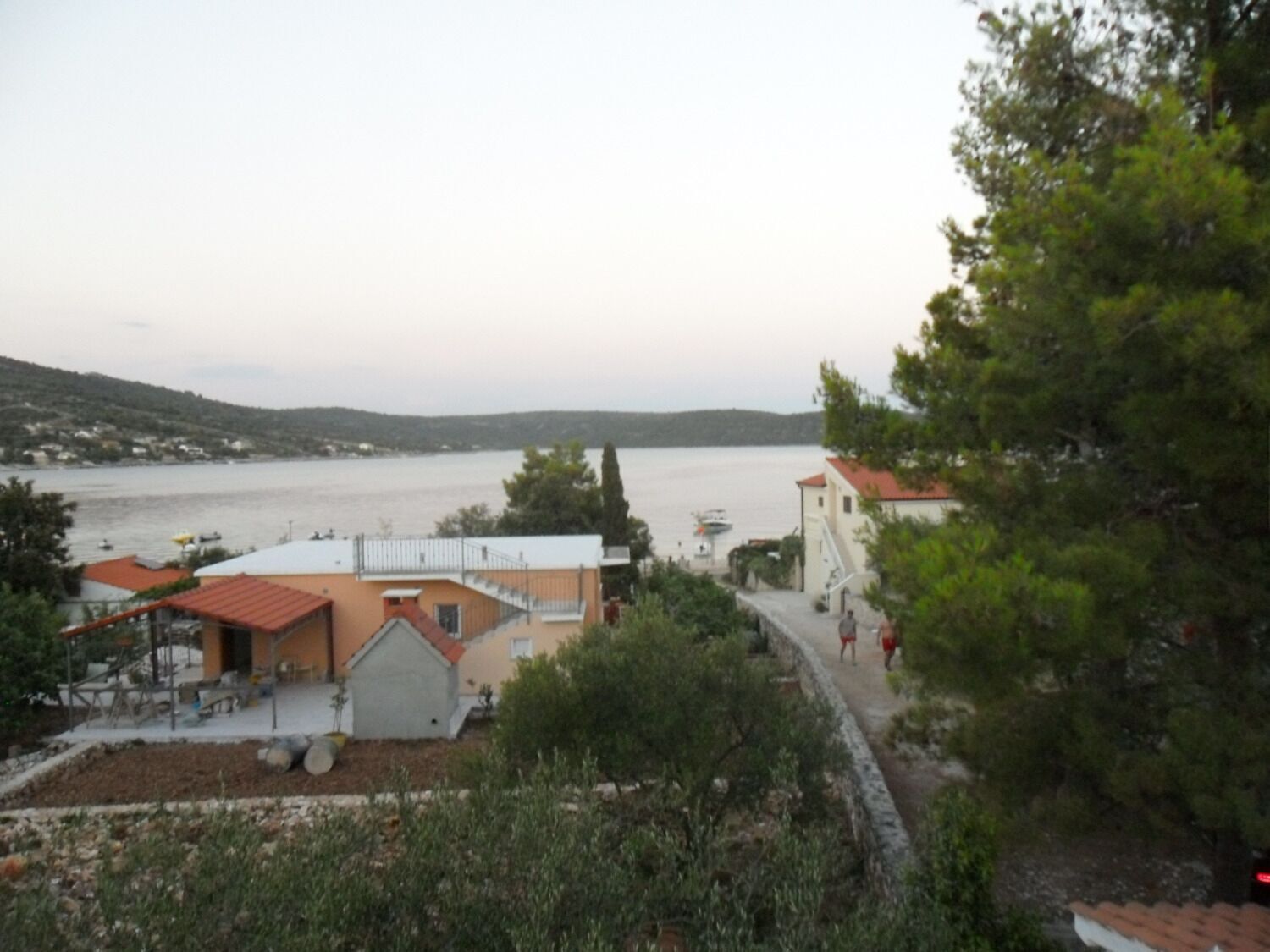 A coastal view with buildings, a pathway, and a body of water.