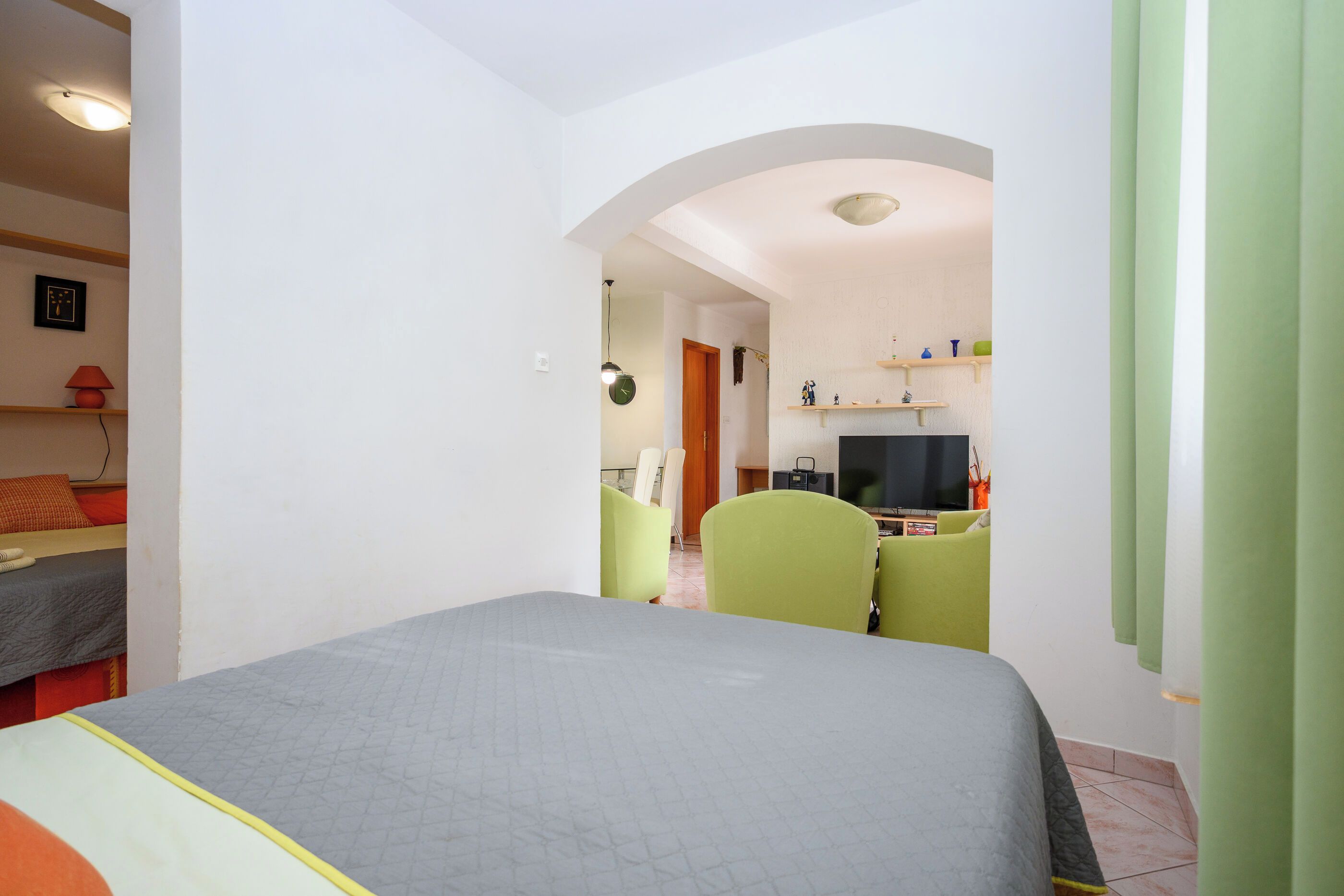 Une chambre d’hôtel avec un lit, un bureau, une chaise et un téléviseur.