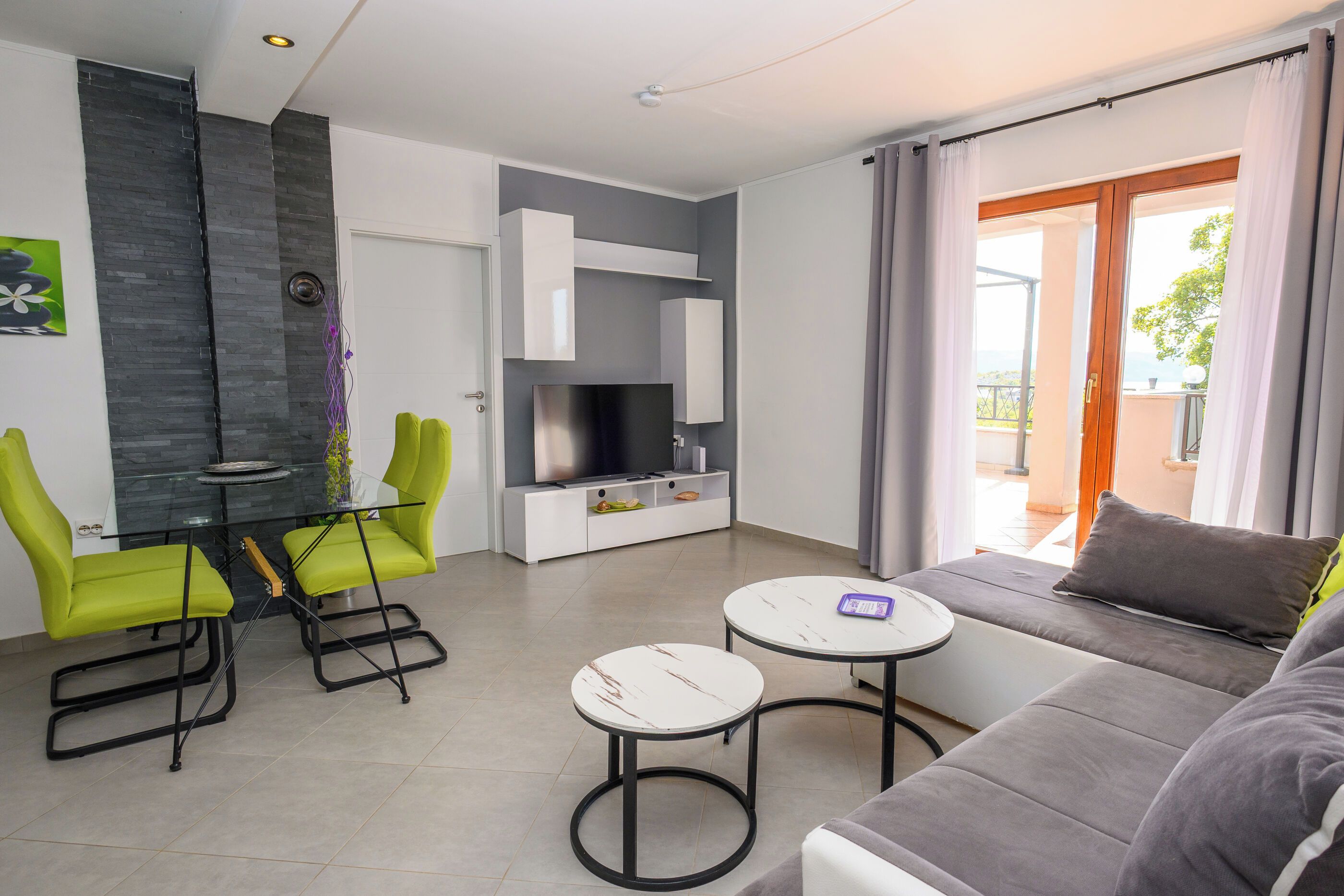 Una sala de estar moderna con un sofá, dos sillones, una mesita y un televisor.