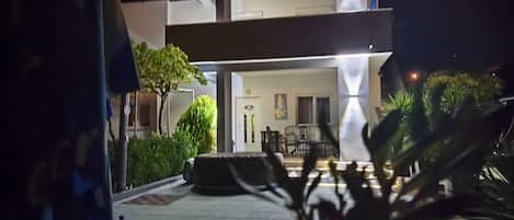 Un bâtiment moderne doté d’un toit plat et d’un patio aménagé avec du mobilier d’extérieur.