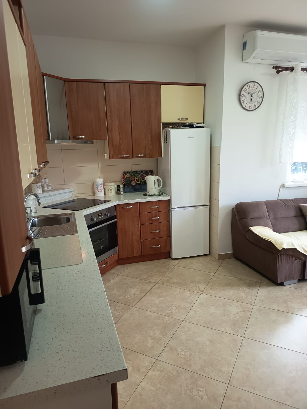A kitchen with wooden cabinets, a refrigerator, a stove, and a sink.