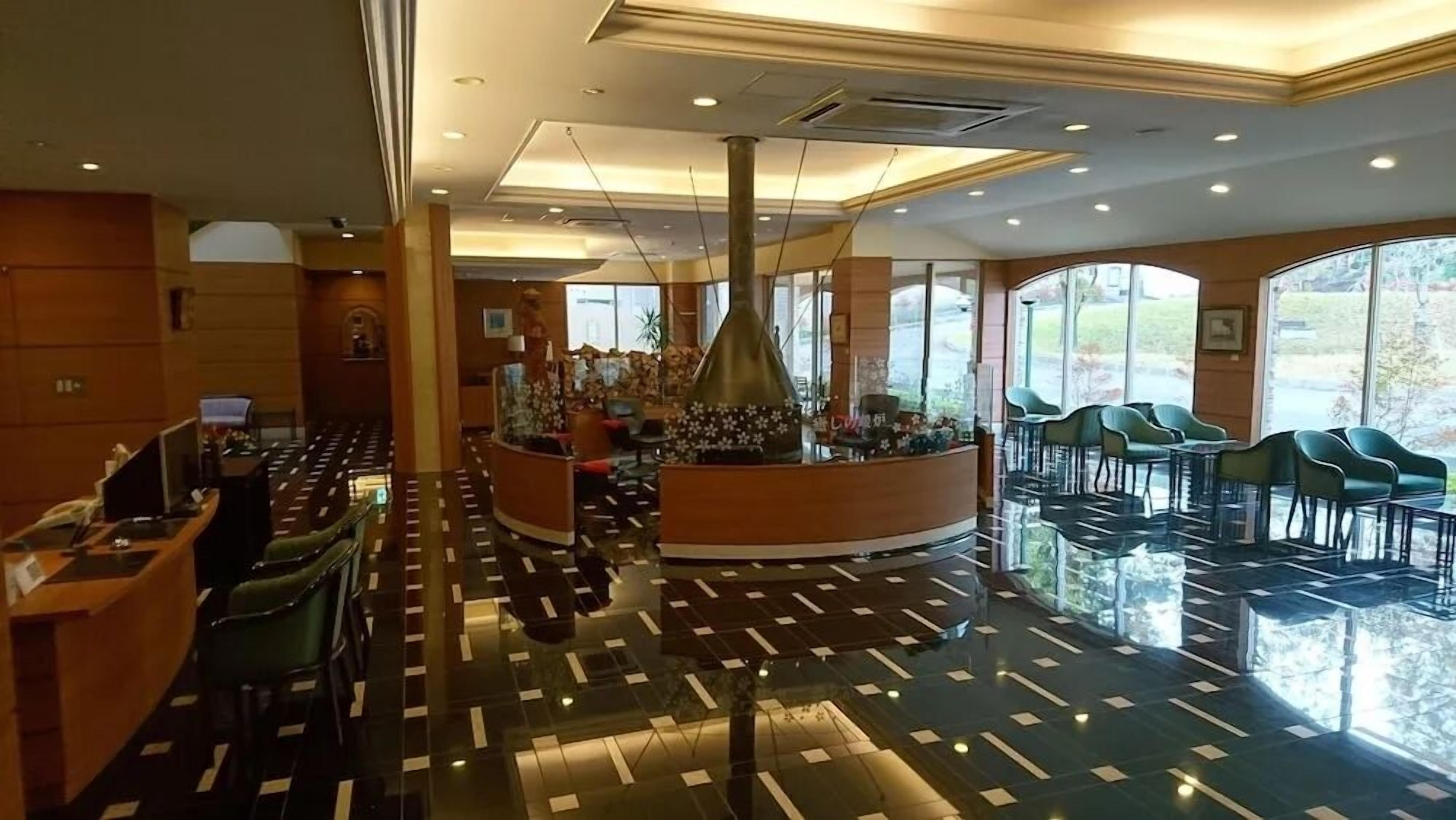 A hotel lobby with a reception desk, seating area, and large windows offering views.