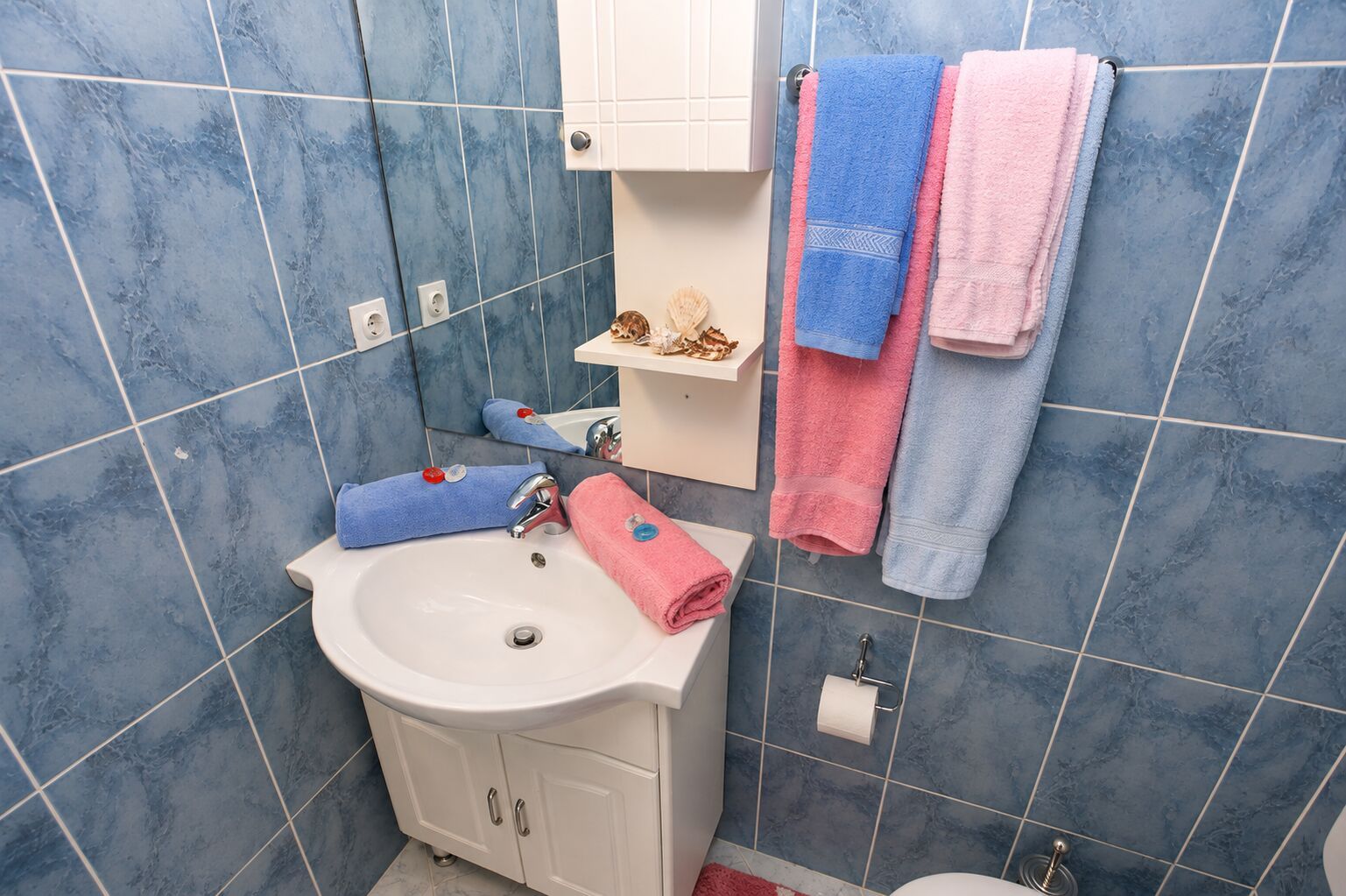 Baño con lavamanos, espejo y barra para toallas.