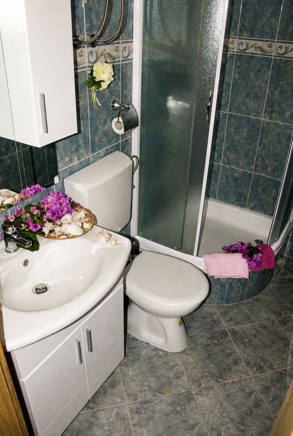 Egy fürdőszoba, amelyben WC, mosdókagyló és zuhanyzó található.