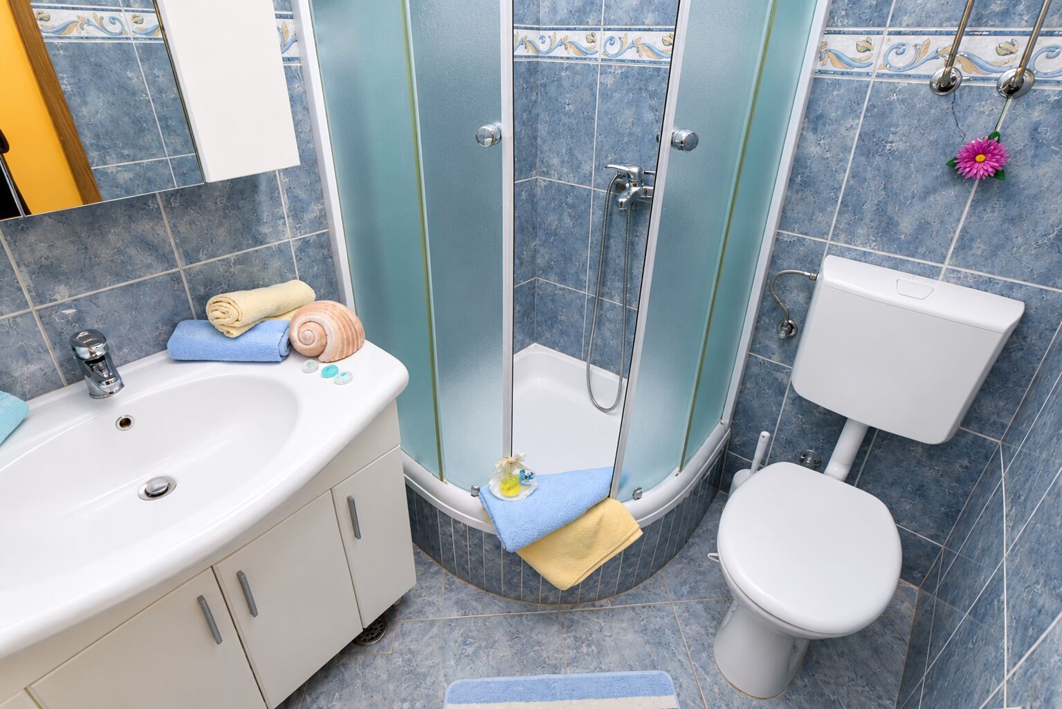 Une salle de bain avec un lavabo blanc, des toilettes et un espace douche.