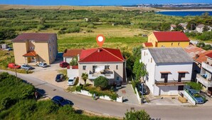 A residential area with houses, a clear sky, and a body of water in the distance. - Apartment San (Povljana)