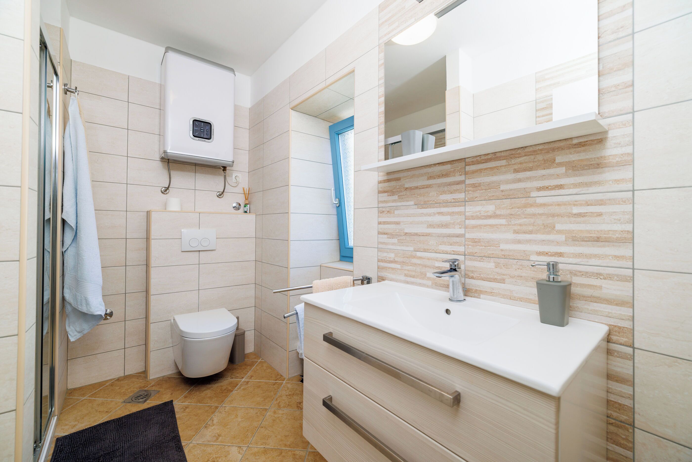 A modern bathroom with a white sink, a toilet, and a shower area.