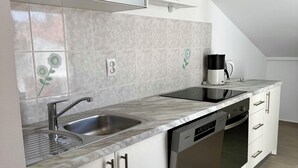 Una cocina moderna equipada con lavavajillas, cafetera y microondas.