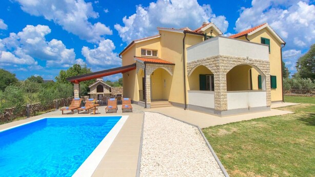 A two-story house with a swimming pool, outdoor seating, and a stone archway. - House Brist (Drnis)