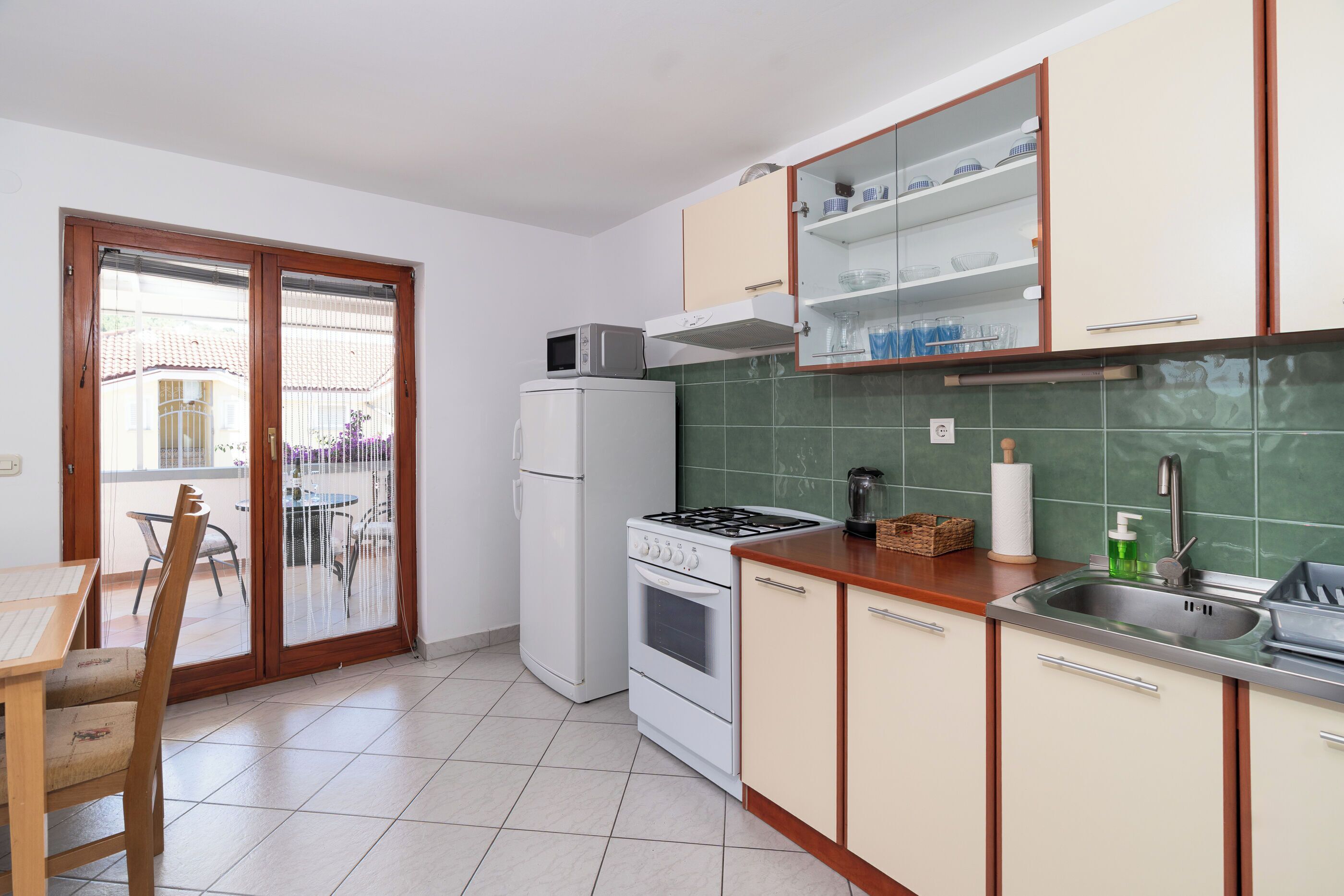 A kitchen with a stove, oven, microwave, and a sink.