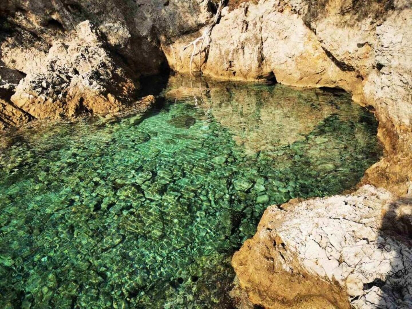 A natural pool surrounded by rocky terrain.