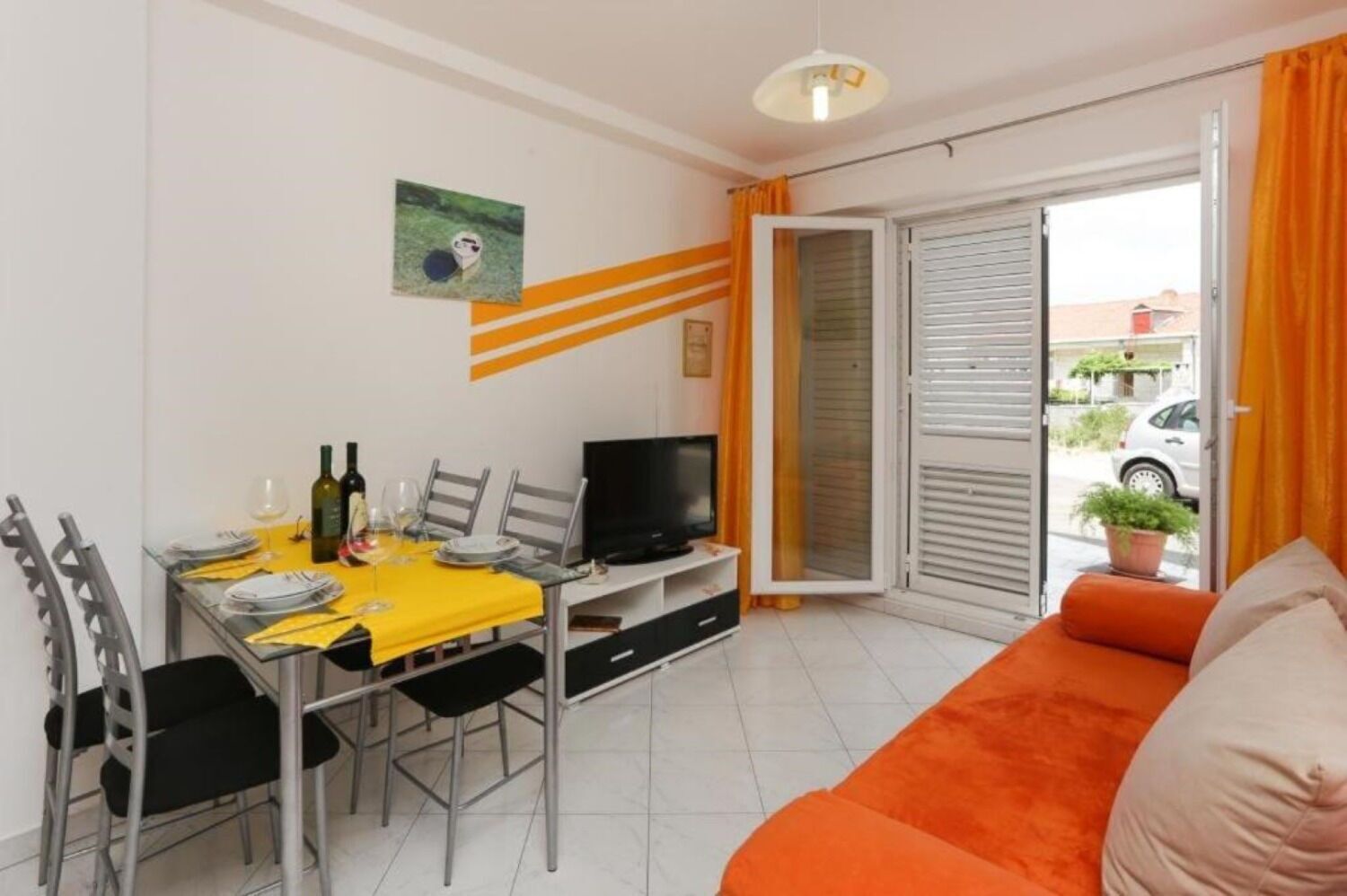 A compact living space with a dining area, a sofa, and a television.