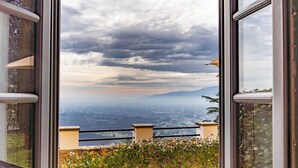 A window with a view of a cityscape and mountains under a cloudy sky. - Executive apartment in Borgo di Matraia (Matraia)