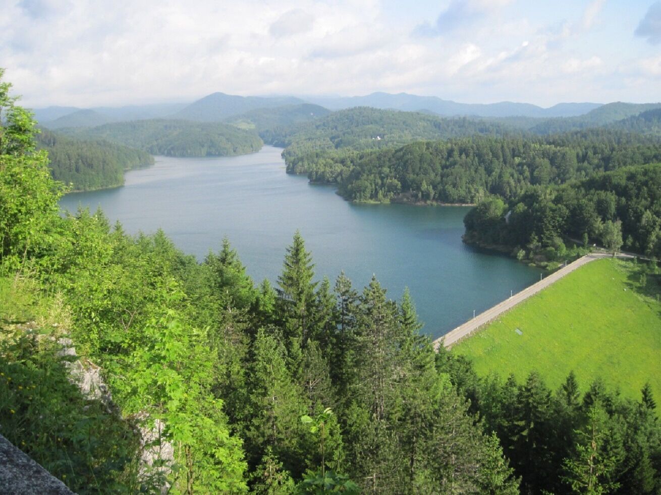 A lake surrounded by dense forest and hills.