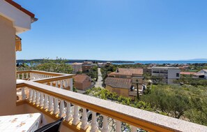 A balcony with a view of a coastal town, including houses and a body of water. - Apartments Dusan (Rab)