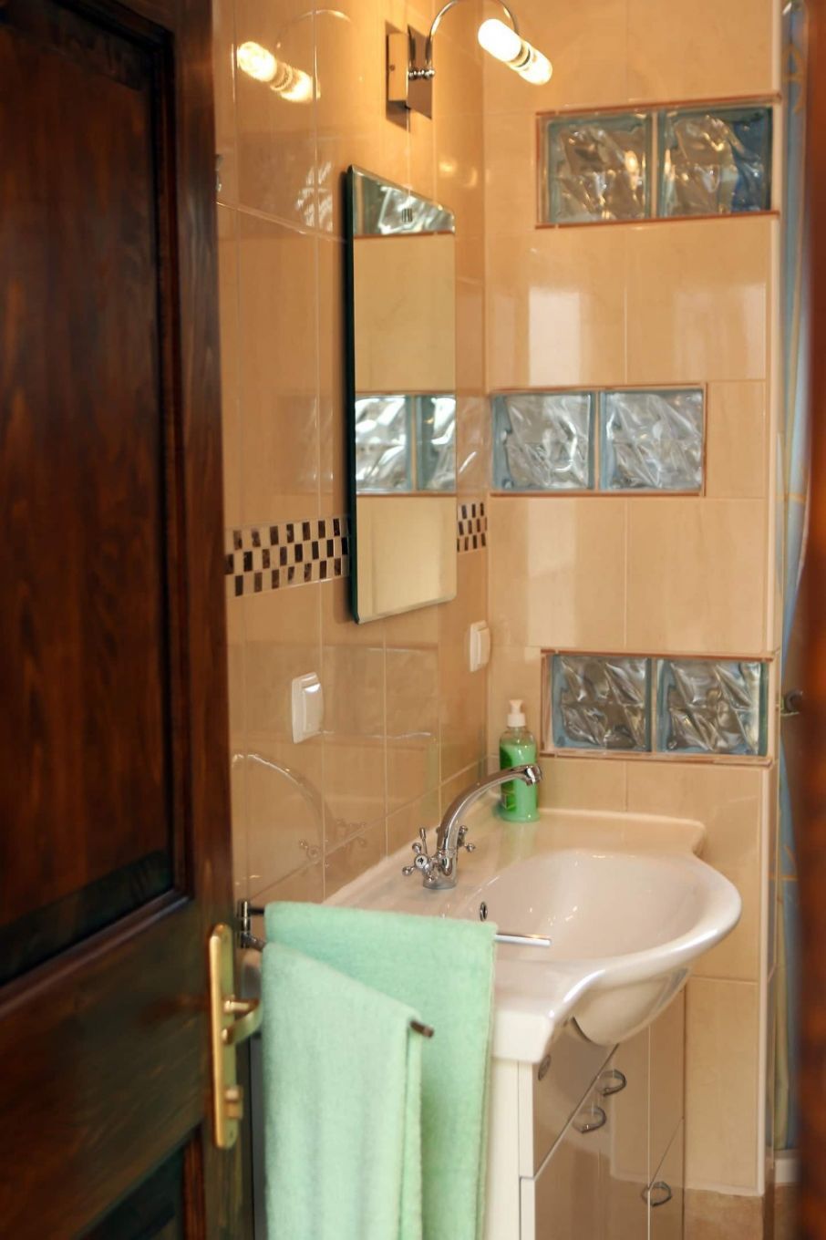Un baño con lavabo, espejo y azulejos decorativos.