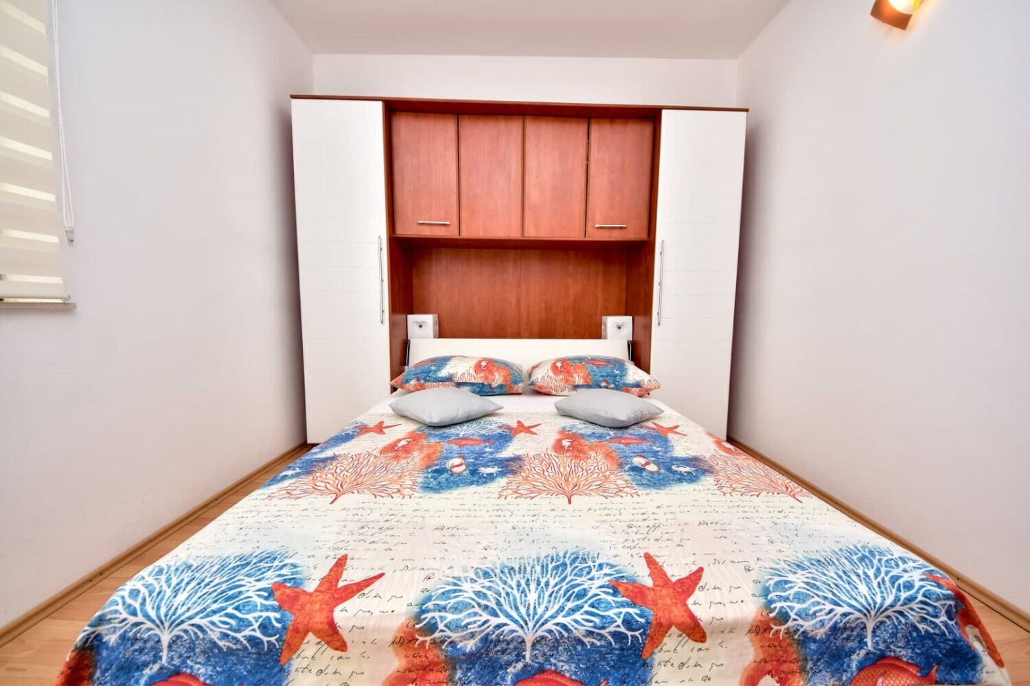 Quarto com uma cama, um guarda-roupa e uma mesa de cabeceira.