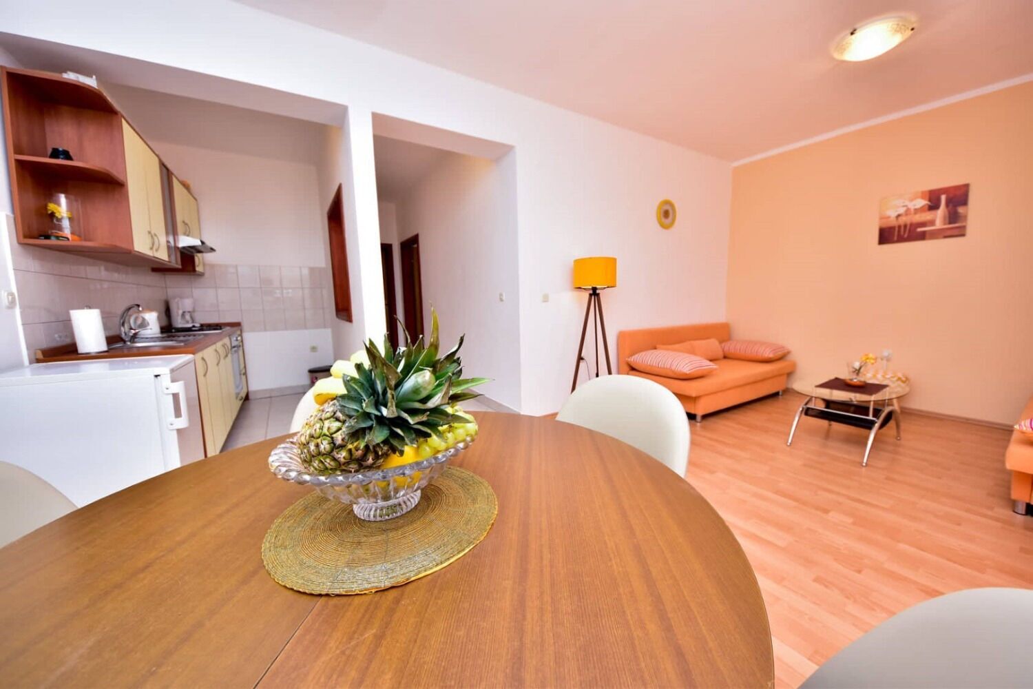 A modern kitchen with white cabinets and a dining area with a wooden table and chairs.