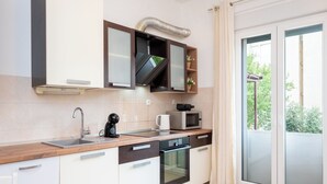 Μια σύγχρονη κουζίνα με εντοιχισμένο φούρνο μικροκυμάτων, φούρνο και νεροχύτη.