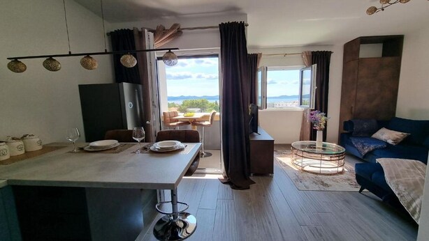 Una sala de estar moderna con comedor, ventanas amplias y vistas al exterior.