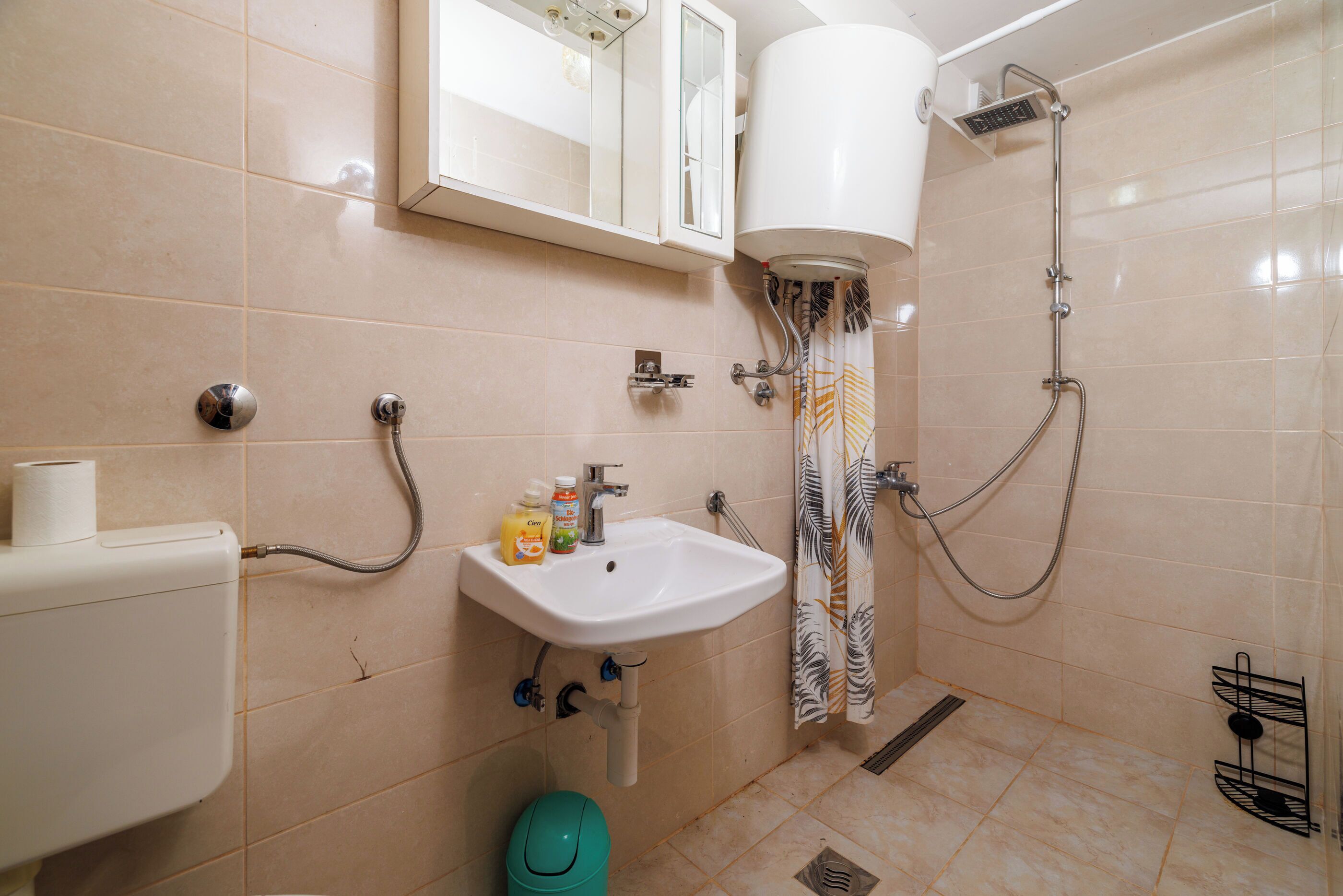A bathroom with a toilet, sink, and shower.
