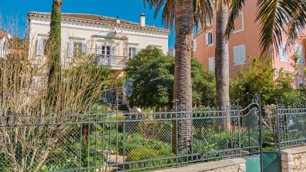 Un bâtiment à la façade blanche, au toit rouge et doté d’un balcon.