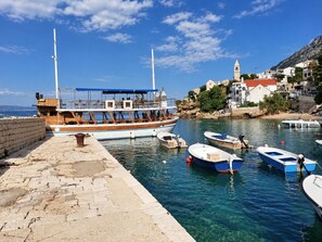 Ein Hafen mit vertäuten Booten, einer Steganlage und Gebäuden im Hintergrund.