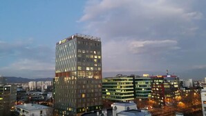 A high-rise building with multiple floors, large windows, and a rooftop sign. - Apartment Asja (Zagreb)