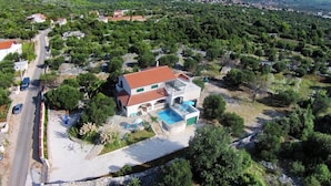 A two-story house with a swimming pool, surrounded by greenery and hills. - House Stone&olive (Marina)