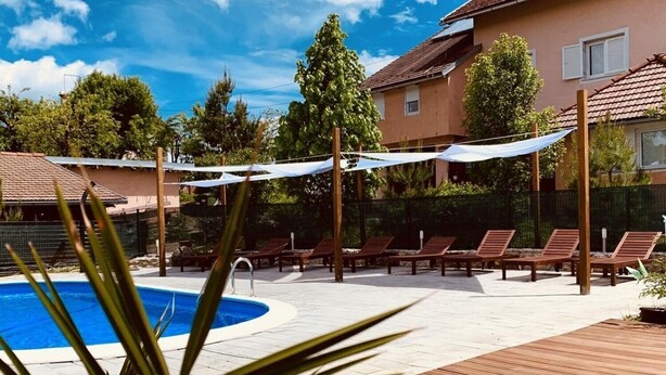 Un espace piscine avec des chaises longues et une terrasse en bois.