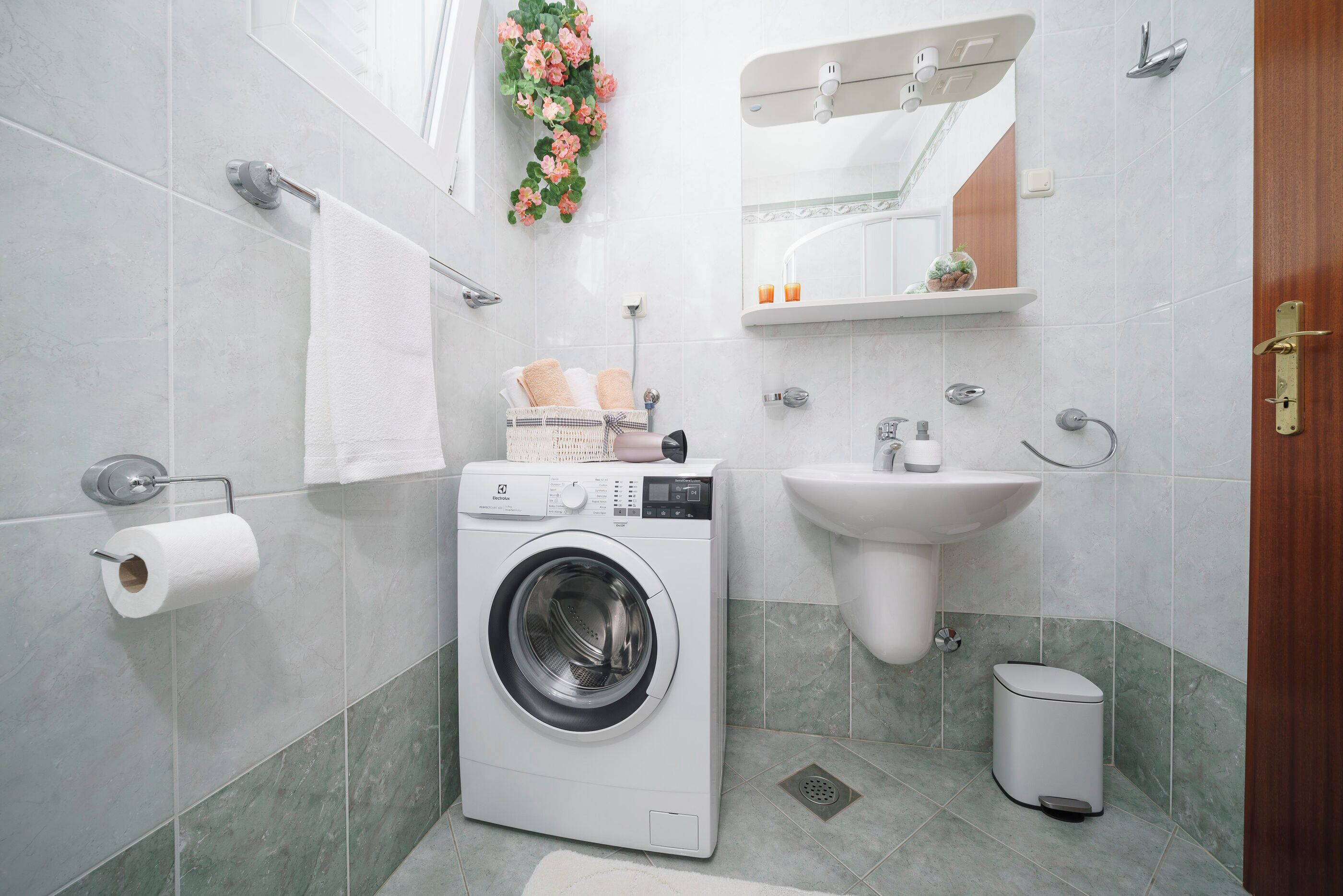 Ein modernes Badezimmer mit Waschmaschine, Waschbecken und Toilette.