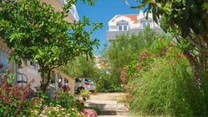 A residential street with houses, a car, and lush greenery. - Apartments Josip (Vodice)